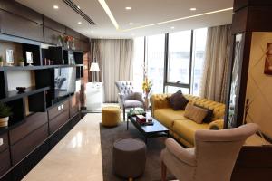 a living room with a yellow couch and chairs at Londrina Hotel in Amman