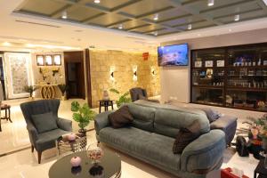 a living room with a couch and chairs and a tv at Londrina Hotel in Amman