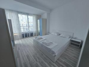 a white bedroom with a bed and a large window at Blue Bay Palace Apart Complex in Pomorie +92 photos