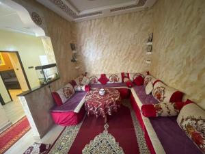 a living room with a couch and a table at Grand appartement fabuleux in Agadir +16 photos