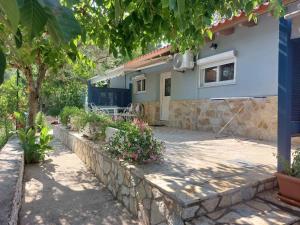 a house with a stone wall in front of it at Soldatos Rooms in Marantochori
