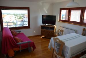 a living room with a television and a table and chairs at Apartments Premantura in Premantura