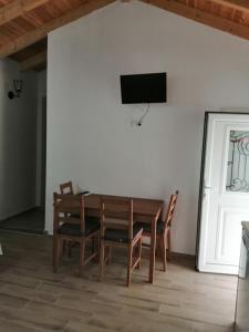 a dining room with a table and chairs and a television on a wall at Soldatos Rooms in Marantochori