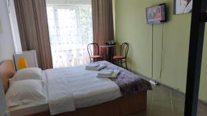 a bedroom with a bed with two towels on it at Vila Timona in Eforie Nord