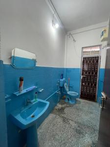 Un baño con un lavabo azul y un inodoro. en Notel Stays, en Jorhat
