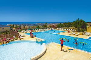 a pool at a resort with people playing in it at LES PIEDS DANS L'EAU A PALAVAS ! Mer à 50 m ! MHome 6 Pers climatisé T confort CAMPING 4 ETOILES in Palavas-les-Flots