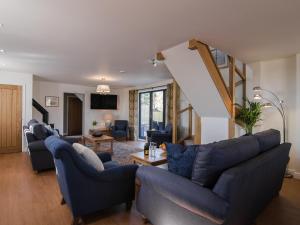 a living room with blue couches and a staircase at The Coach House - Ukc2772 in Sandwich