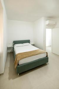 a bed in a white room with a green frame at Casa Vacanze Vanda in Ostuni