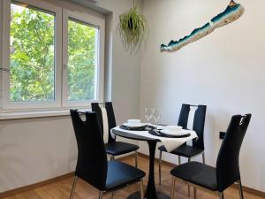 a dining room with a table and chairs and a window at Fehér Balaton Apartman in Balatonalmádi