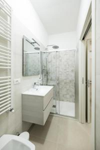 a white bathroom with a sink and a shower at Casa Vacanze Vanda in Ostuni