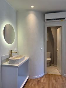 ein Badezimmer mit Waschbecken und Spiegel in der Unterkunft Dousmani Old Town Studio in Korfu-Stadt