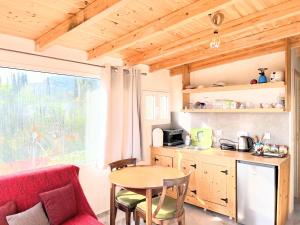 a small kitchen with a table and a red couch at Linda House Corfu in Gastouri