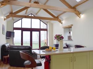 a kitchen and living room with a table and chairs at Southlands Barn in Saundersfoot