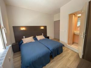 a bedroom with a blue bed and a window at Number 14 in Argelès-Gazost