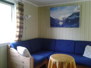 a living room with a blue couch and a table at Lunheim in Geiranger in Geiranger