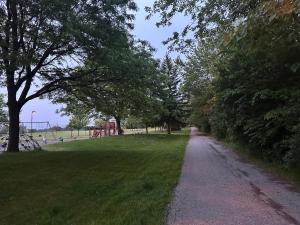 a path in a park with trees and a playground at Spacious room near subway & shops in Toronto