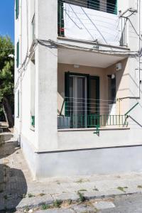 a white building with a balcony on a street at Casa Vacanze Vanda in Ostuni