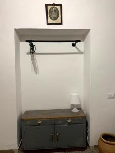 a room with a dresser with a lamp on it at La tua casa a Pitigliano in Pitigliano