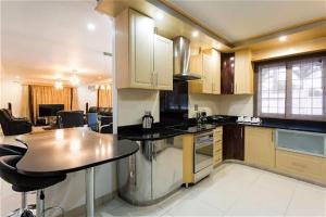 a kitchen with a counter and a table in it at Buckleigh Guesthouse in Durban