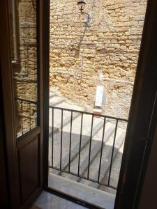 eine offene Tür mit Blick auf eine Steinmauer in der Unterkunft Acchianata Santo Spirito in Agrigento
