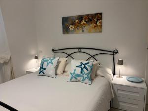 a bedroom with a bed with blue and white pillows at Casa Leòn in Nettuno