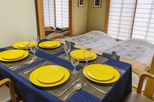 a table with yellow plates and glasses on it at Oiwake House 1A in Karuizawa