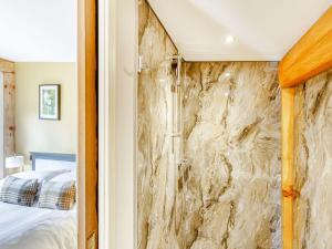 a bedroom with a stone wall next to a bed at Rhosyn - Uk40260 in Llangadfan