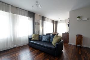 a living room with a black couch and wooden floors at Dimora Cannavini in Castel di Sangro