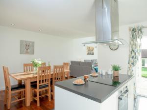a kitchen and living room with a table and a dining room at Wonkey Donkey Cottage in Seaton +20 photos