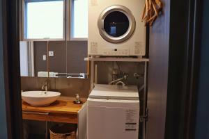 a kitchen with a sink and a washing machine at 恩納村リゾート貸別荘 COCO PLUS No1 in Onna +23 photos