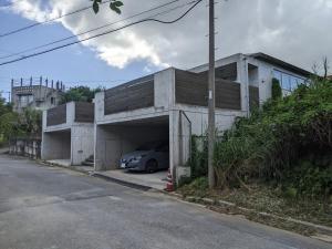 a car parked in a garage next to a building at 恩納村リゾート貸別荘 COCO PLUS No1 in Onna
