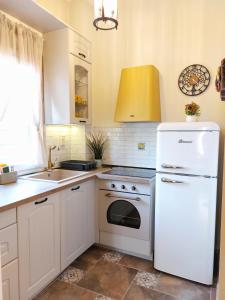 a kitchen with a white refrigerator and a sink at Iliaxtida Apartment in Agia Paraskevi