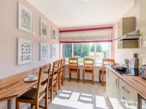 une cuisine et une salle à manger avec une table et des chaises dans l'établissement Harebell Cottage, à Addlethorpe