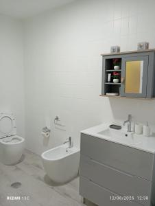 a white bathroom with a toilet and a sink at Piso en Alexandre Bóveda in O Grove