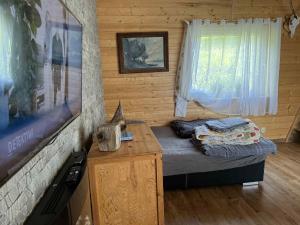 a bedroom with a bed and a tv in a log cabin at Lipowy zakątek 