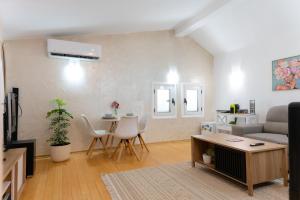 a living room with a couch and a table at Airport Apartments Una in Mitrovići