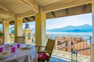 a table on a balcony with a view of the water at Appartamento Ronco in Ghiffa +21 photos