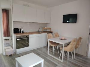 a kitchen with a table and a table and chairs at Eva Apartman in Prokuplje