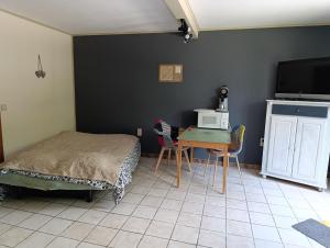 a bedroom with a bed and a table with a microwave at Chez les Petits in Rochefort