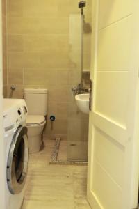 une salle de bain avec toilettes et lavabo et une machine à laver dans l'établissement One bedroom apartment in Aqua palm resort before Al Gouna, à Hurghada