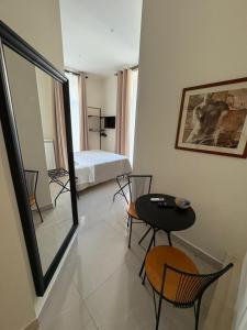 a room with a bed and a table and chairs at Misciù in Naples