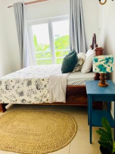 a bedroom with a bed with a window and a rug at Ku-khaya Zanzibar, cozy apartment in Fumba Town in Mchamba Wima