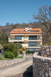 a building with a stone wall next to a road at Villa Orka in Omišalj