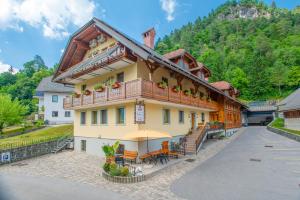 un grande edificio giallo con balcone di Rooms & Apartments Pr Matjon a Bled