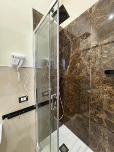 a shower with a glass door in a bathroom at Misciù in Naples