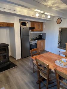 una cucina con un tavolo di legno e una stufa di Petite maison a Les Bondons