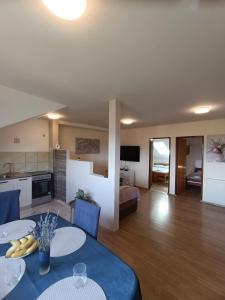 een woonkamer met twee eettafels en een keuken bij Apartman PETRA ZABOK in Zabok