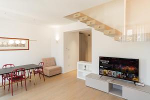 a living room with a dining table and a tv at Domus Verona - Dimora Capretto in Verona