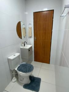 a bathroom with a toilet and a sink with a blue rug at Casa Temporada Oasis no Sertão in Triunfo +7 photos