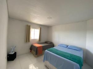 a small bedroom with two beds and a window at Casa Temporada Oasis no Sertão in Triunfo